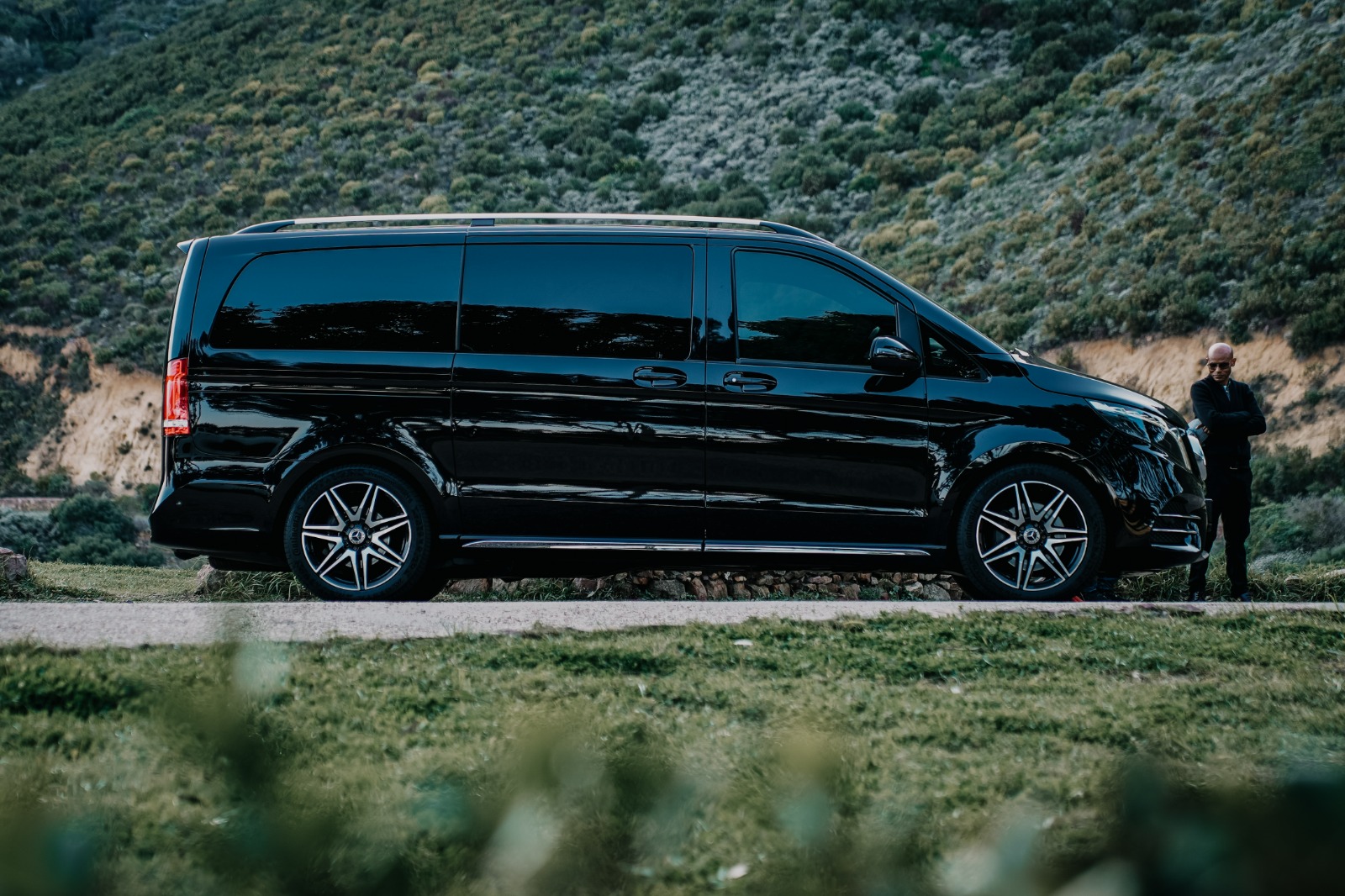 Black Mercedes-Benz V-Class side profile with chauffeur