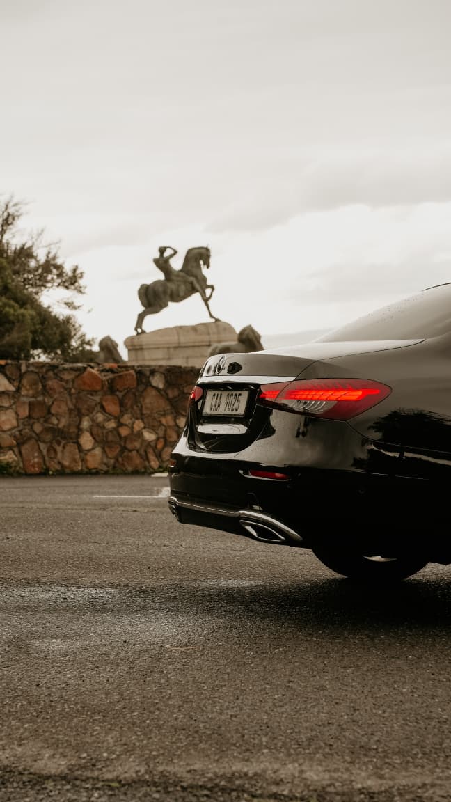 Mercedes-Benz E-Class rear profile near a Cape Town monument
